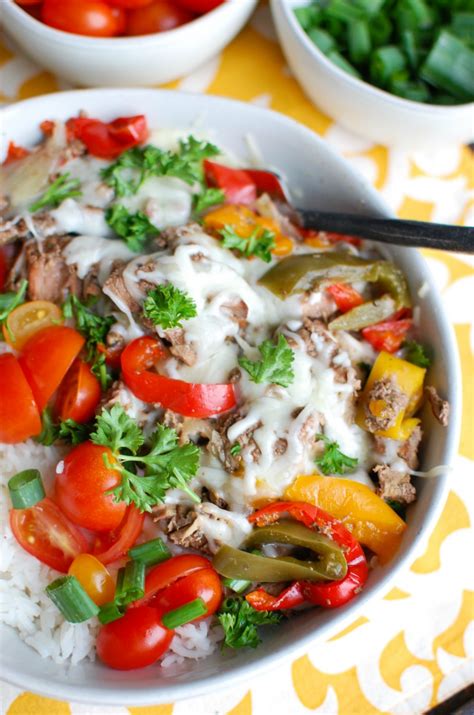 Tender, sliced beef steak stacked on seasoned rice with onions & bell peppers topped with a creamy provolone cheese sauce. Slow Cooker Philly Cheesesteak Rice Bowls - A Cedar Spoon