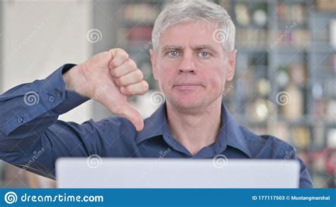 Portrait Of Disappointed Middle Aged Man Showing Thumbs Down Stock