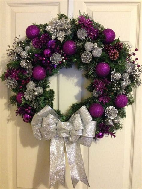 A Purple And Silver Christmas Wreath Hanging On A Door