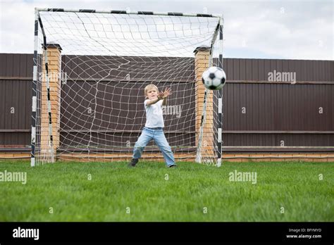 Young Boy Standing In Football Goal Catching Ball Stock Photo Alamy