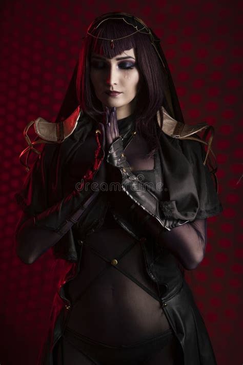 A Beautiful Leggy Busty Cosplay Girl Wearing An Erotic Leather Costume Poses And Makes Gestures