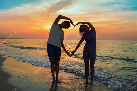 silhueta de duas pessoas apaixonadas ao pôr do sol — fotografias de stock © tiplyashina 51024025