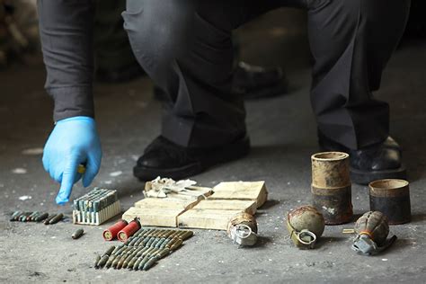 An Explosive Ordnance Disposal Officer Inspects Three Hand Grenades And