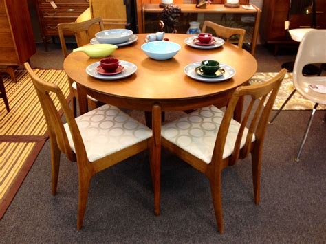 a table with four chairs around it and plates on the table in front of it
