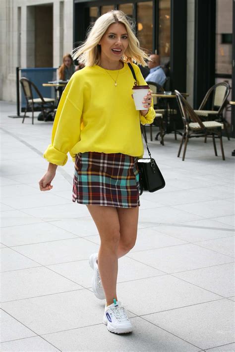 Mollie King Wears A Yellow Sweater And A Plaid Mini Skirt As She
