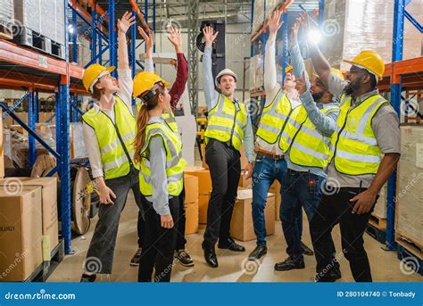 Group of Happy Warehouse Workers Celebrating Success in Warehouse Stock