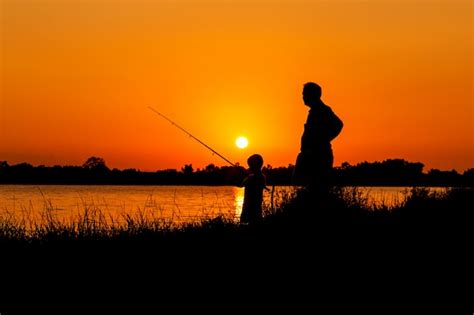 Premium Photo Father And Son Fishing In The River Sunset Backgrond