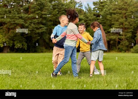 Happy Children Playing Round Dance At Park Stock Photo Alamy