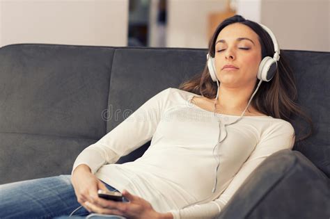 Der traum vom training zu hause. Entspannte Frau, Die Zu Hause Musik Auf Dem Sofa Hört ...