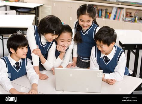 Students Gathered Around A Computer In The Classroom Stock Photo Alamy