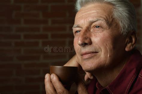 Portrait Of Smiling Senior Man Drinking Coffee At Home Stock Image