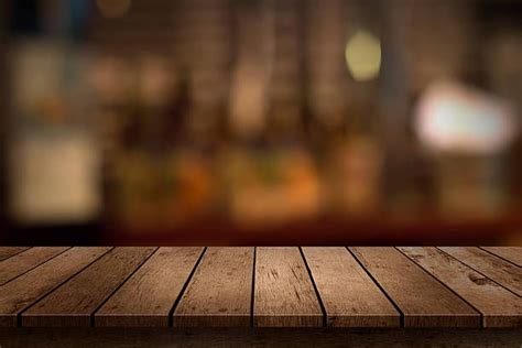 Деревянный стол с видом на размытым фон напитки в баре стоковое фото