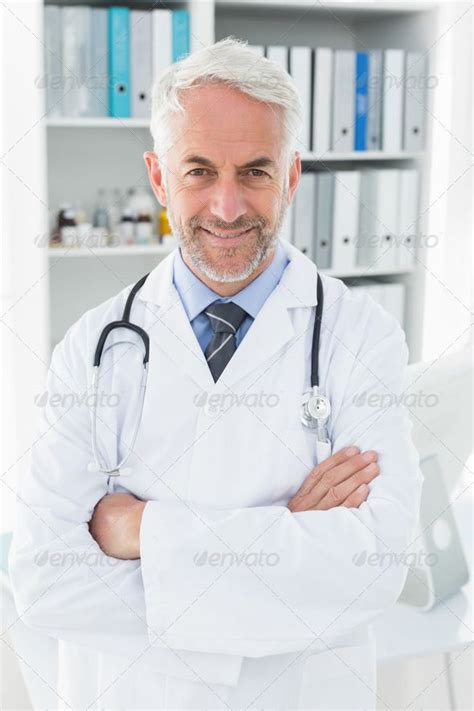 Portrait Of A Smiling Confident Male Doctor Standing With Arms Crossed