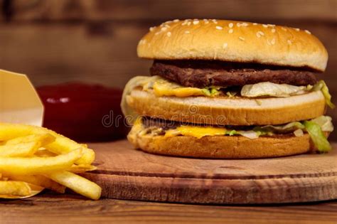 Delicious Big Hamburger With French Fries And Ketchup On Wooden Table