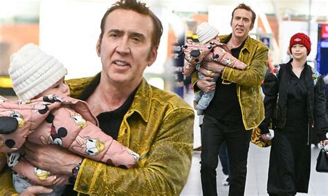nicolas cage carries daughter august in his arms after he and wife riko shibata touch down at