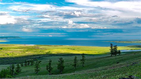 Green Grass Landscape And Blue Sea Under Cloudy Sky 4k Hd