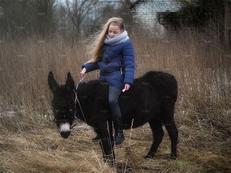 A Girl Rides A Donkey Featuring A Girl And Rides Animal Stock