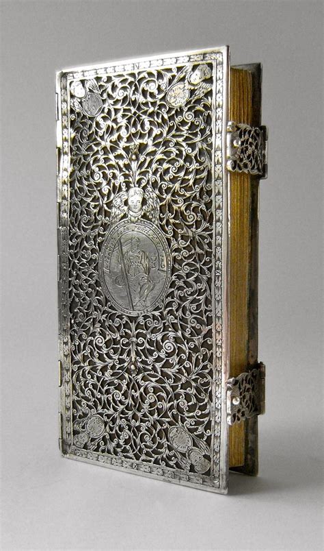An Intricately Designed Silver Book With A Medallion On The Front And