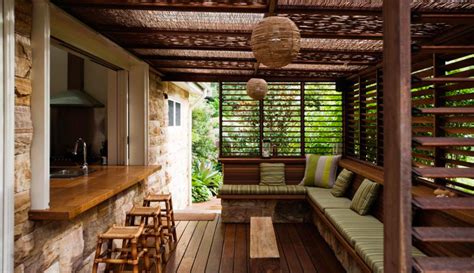 An Outdoor Living Area With Wood Flooring And Wooden Furniture On The
