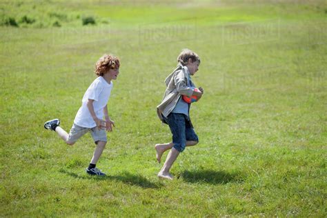 Children Chasing Each Other Outdoors Stock Photo Dissolve