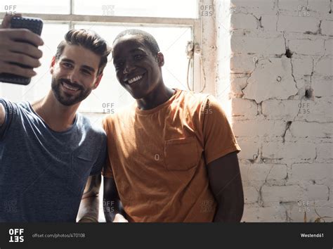 Two Smiling Young Men Taking A Selfie At The Window Stock Photo Offset