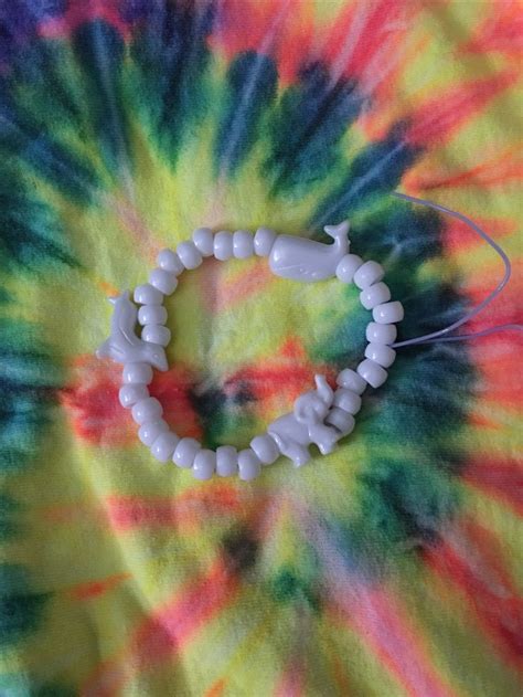A Tie Dyed Shirt With A Beaded Bracelet On It