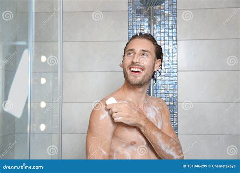 Jeune Homme Attirant Prenant La Douche Avec Du Savon Image Stock