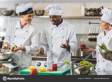 Smiling Multicultural Chefs Talking Restaurant Kitchen — Stock Photo © ArturVerkhovetskiy #188599570