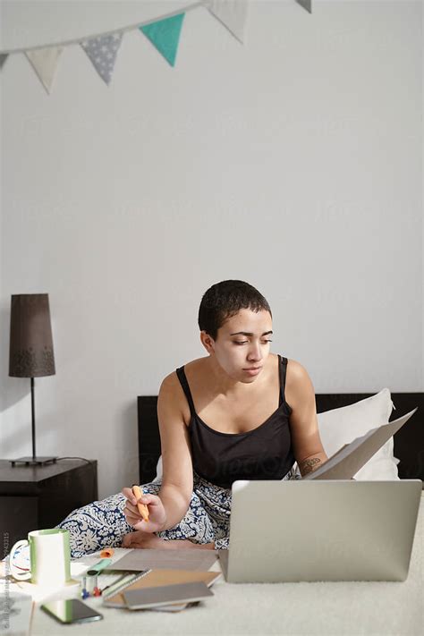 Girl Freelancer Sitting On Bed And Working With Papers By Stocksy Contributor Guille Faingold