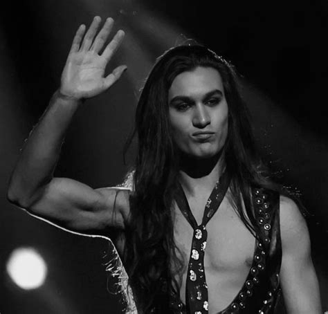 A Man With Long Hair And No Shirt On Holding His Hand Up In The Air