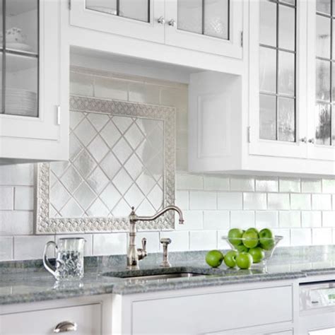 The dual elements make the backsplash unique, and the darker marble flows this glossy white kitchen looks as if it came straight out of a cozy cabin. white patterned subway tile backsplash idea | Kitchen ...
