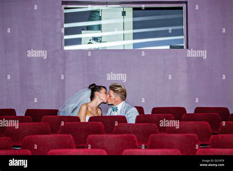 Young Couple Kissing In Movie Theater On Their Wedding Day Stock Photo