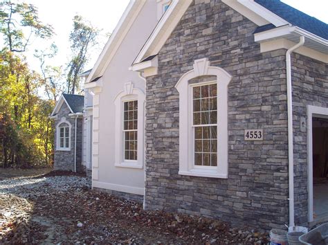 A Brick House With White Trim And Windows
