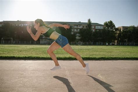 Female Sprinter Athlete Getting Ready To Start A Race Stock Image