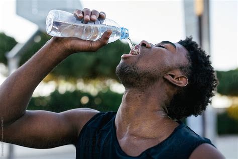 African American Man Drinking Water After To Play Basketball By