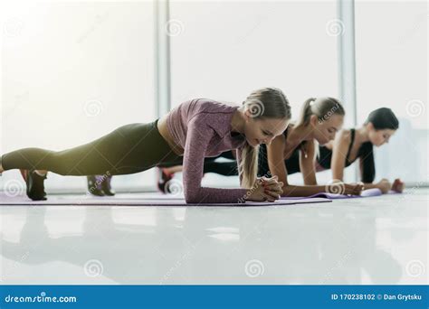 Three Attractive Sport Girls Smiling While Doing Plank Exercise Lying