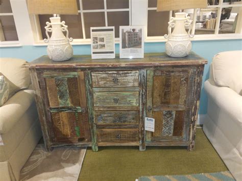 two white vases sitting on top of an old wooden cabinet in a living room