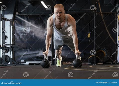 Fit And Muscular Man Doing Horizontal Push Ups On Dumbbells In Gym