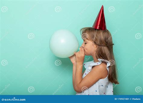 Little Girl Celebrating Birthday And Blowing A Balloon Stock Image