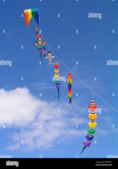 A Collection Of Multi Colored Kites Against A Bright Blue Sky Stock