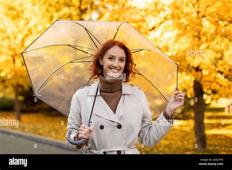 Happy Caucasian Millennial Woman With Red Hair In Raincoat With