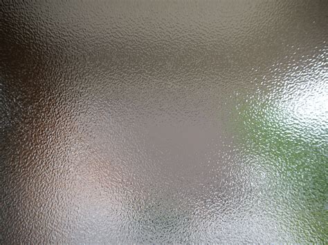 A Close Up View Of A Shiny Surface With Green And White Highlights On The Glass