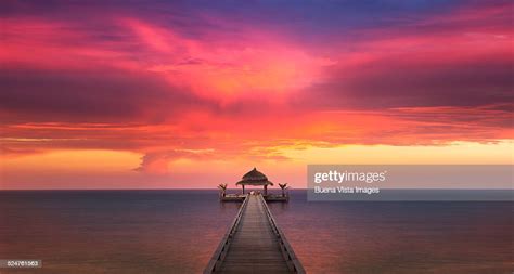 Red Sunset Over Dock On Ocean Stock Photo Getty Images