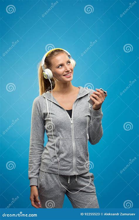 Beautiful Blond Fit Caucasian Lady In Grey Sport With Headphones Listening Music Stock Image