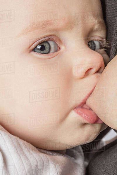 Close Up Portrait Of Cute Baby Girl Being Breastfed By Mother Stock Photo Dissolve