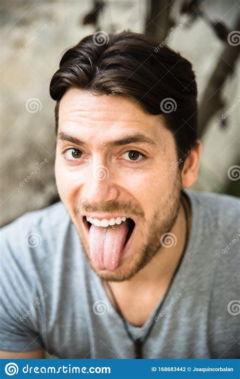 Portrait Of Young Model Man With Funny Face Sticking Out