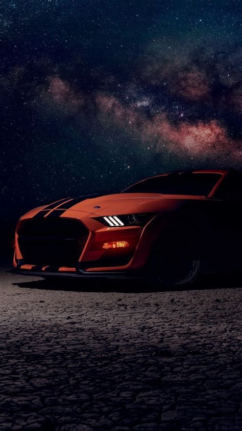 An Orange Sports Car Parked In The Desert At Night