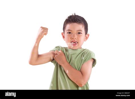 A Young Boy Shows Us His Arm Muscle In This Studio Setting Stock Photo