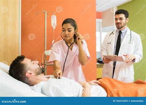 Male And Female Doctor Treating Patient At Hospital Stock Photo Image