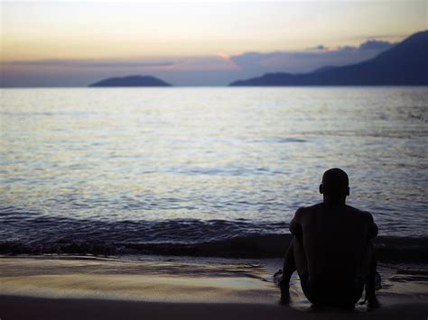 Man Sitting Alone On A Beach Photograph By Win Initiativeneleman